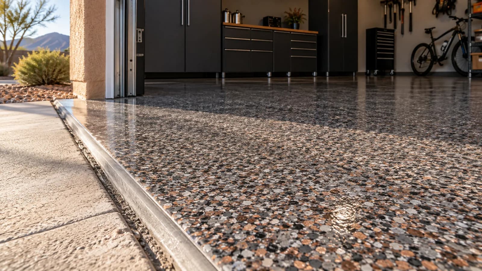 Illustrative close-up of a gray and copper full-flake floor at a garage threshold